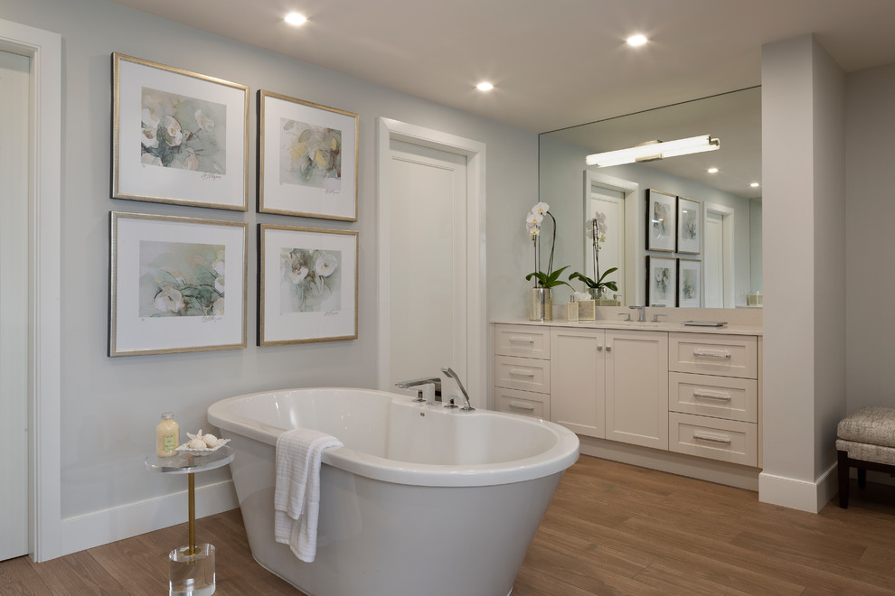 Foto di una stanza da bagno padronale stile marino con ante in stile shaker, vasca freestanding, pareti grigie, pavimento in legno massello medio, lavabo sottopiano, ante beige e top beige