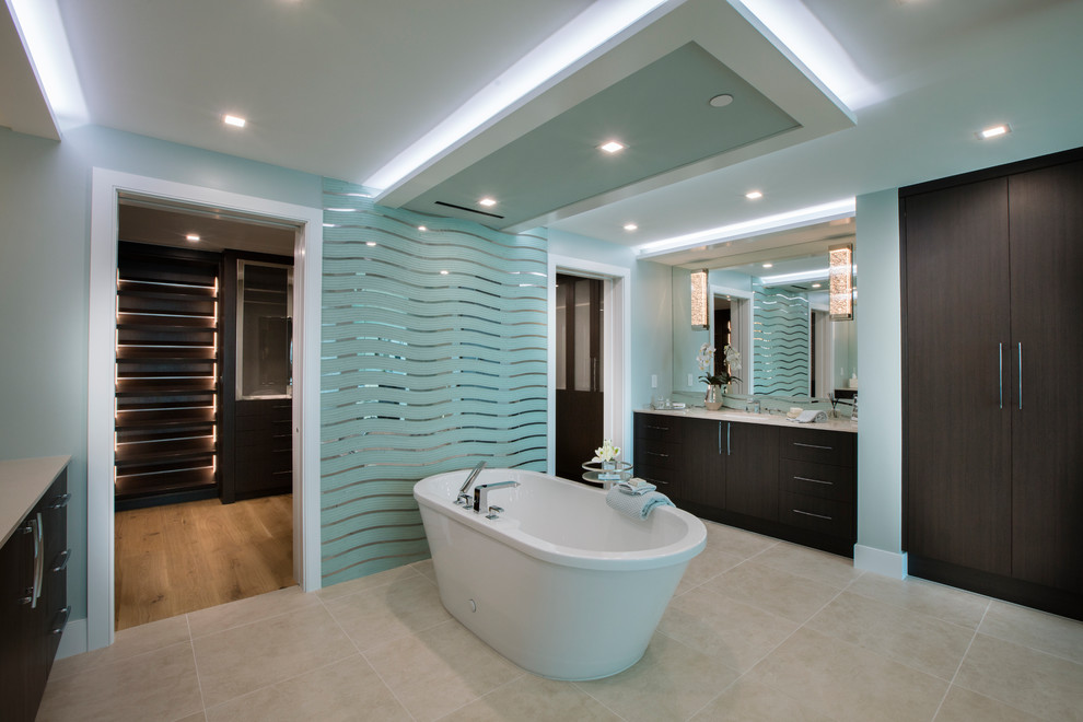На фото: большая главная ванная комната в современном стиле с плоскими фасадами, темными деревянными фасадами, отдельно стоящей ванной, унитазом-моноблоком, бежевой плиткой и синими стенами