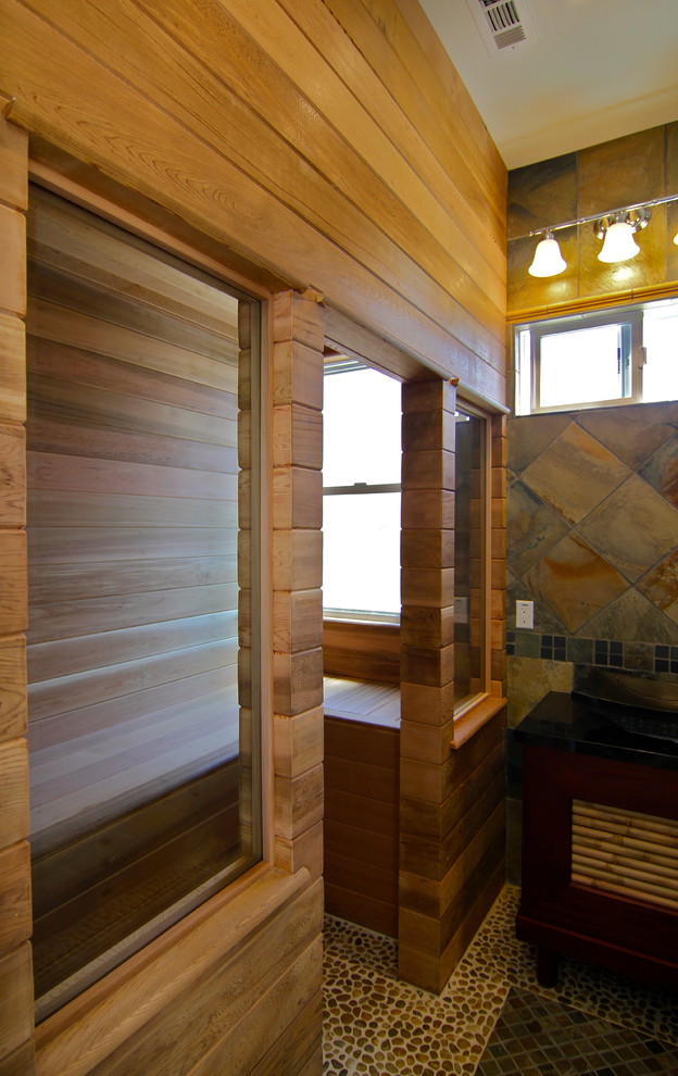 Immagine di una grande sauna tradizionale con zona vasca/doccia separata, piastrelle grigie, piastrelle in ardesia, pareti marroni, pavimento con piastrelle di ciottoli e doccia aperta