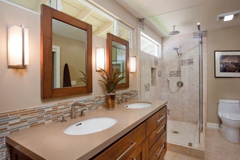 Example of a mid-sized trendy master multicolored tile porcelain tile corner shower design in San Diego with shaker cabinets, medium tone wood cabinets, a one-piece toilet, beige walls, an undermount sink and quartz countertops