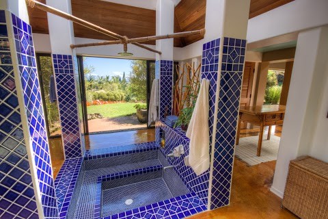 На фото: большая главная ванная комната в стиле фьюжн с гидромассажной ванной, синей плиткой, керамогранитной плиткой, белыми стенами, бетонным полом, коричневым полом и столешницей из гранита с