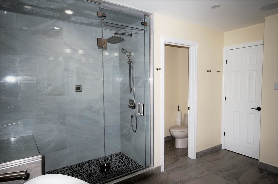 Klassisk inredning av ett stort grå grått en-suite badrum, med skåp i shakerstil, skåp i mörkt trä, ett fristående badkar, en dusch i en alkov, en toalettstol med separat cisternkåpa, grå kakel, porslinskakel, gula väggar, klinkergolv i porslin, ett undermonterad handfat, bänkskiva i kvarts, grått golv och dusch med gångjärnsdörr