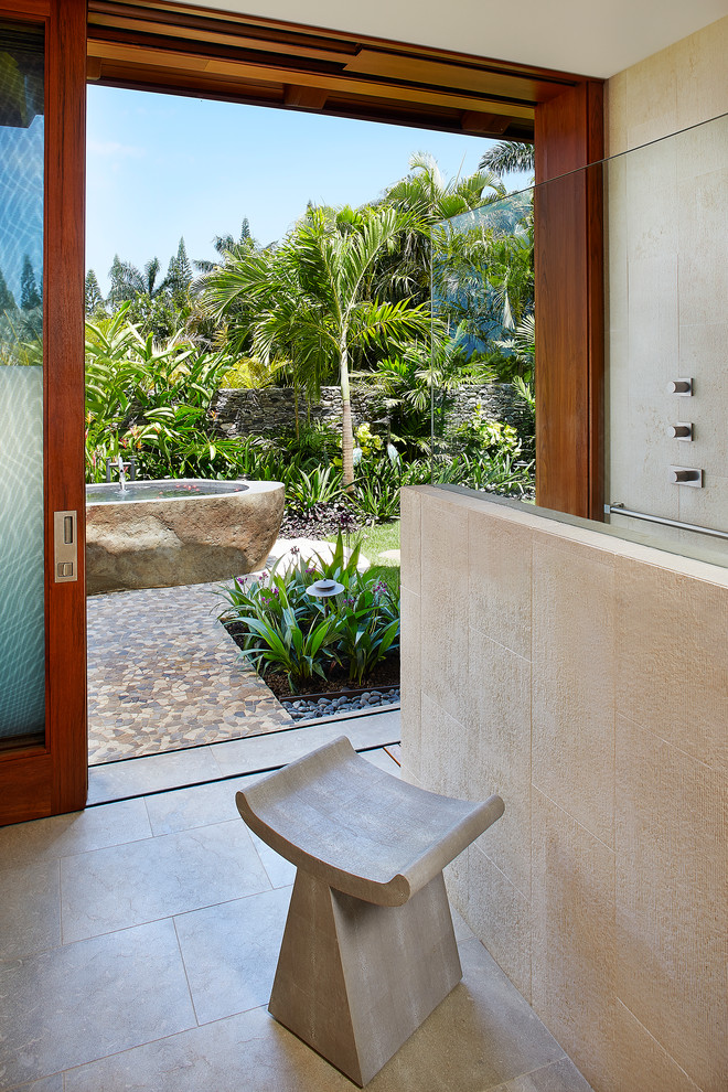 ハワイにある広いトロピカルスタイルのおしゃれな浴室 (置き型浴槽、バリアフリー、ベージュのタイル、ベージュの壁) の写真