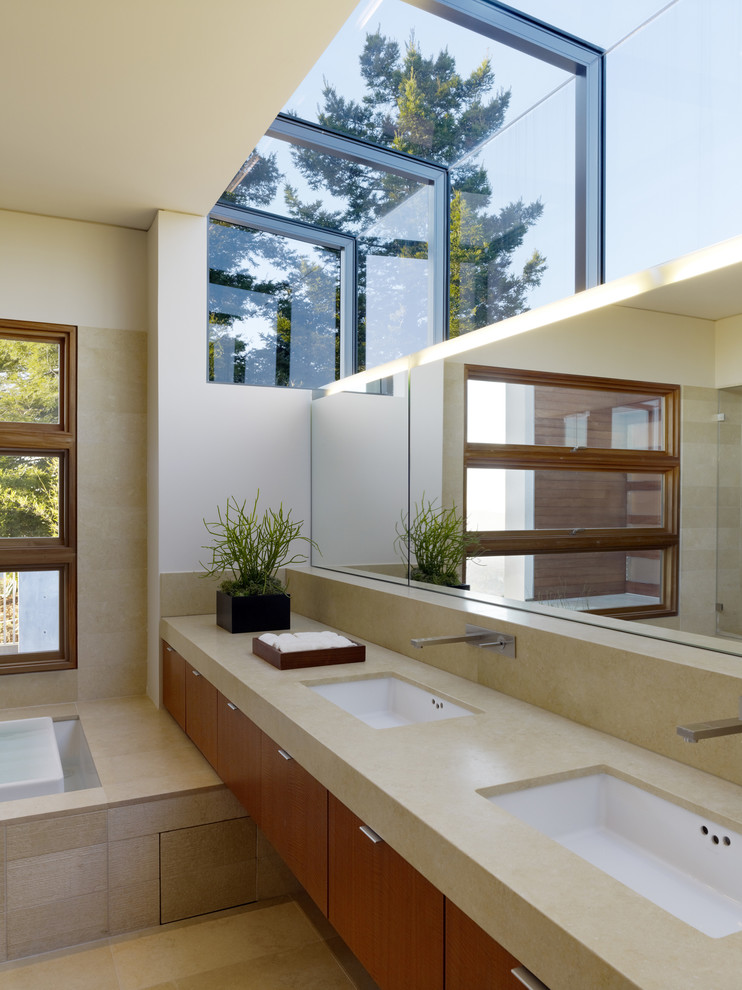 Inredning av ett modernt badrum, med ett badkar i en alkov och ett undermonterad handfat