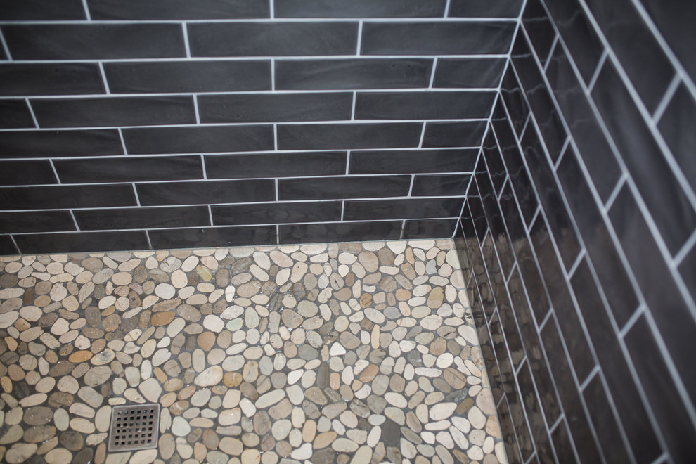 Foto på ett mellanstort funkis badrum med dusch, med svarta skåp, en dusch i en alkov, svart kakel, tunnelbanekakel, grå väggar, klinkergolv i porslin, ett undermonterad handfat, marmorbänkskiva, beiget golv och dusch med gångjärnsdörr