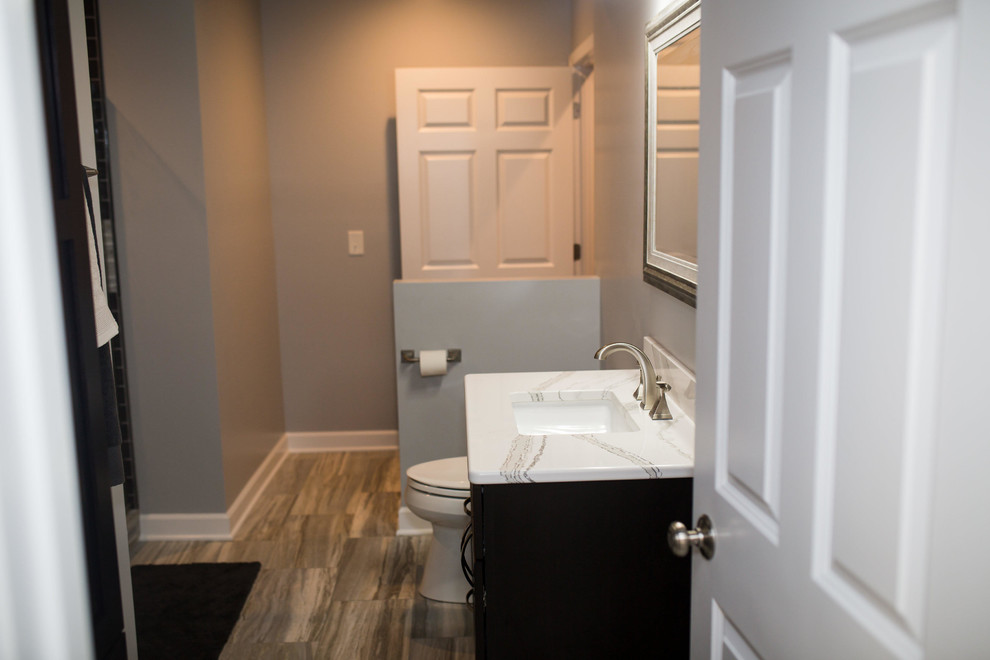 Bild på ett mellanstort funkis badrum med dusch, med skåp i shakerstil, svarta skåp, en dusch i en alkov, svart kakel, tunnelbanekakel, grå väggar, klinkergolv i porslin, ett undermonterad handfat, marmorbänkskiva, beiget golv och dusch med gångjärnsdörr
