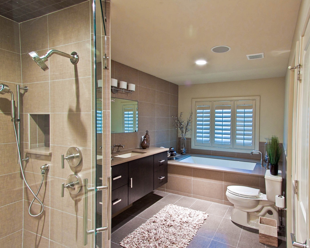 Foto de cuarto de baño actual con armarios con paneles lisos, puertas de armario de madera en tonos medios, bañera encastrada sin remate y baldosas y/o azulejos beige
