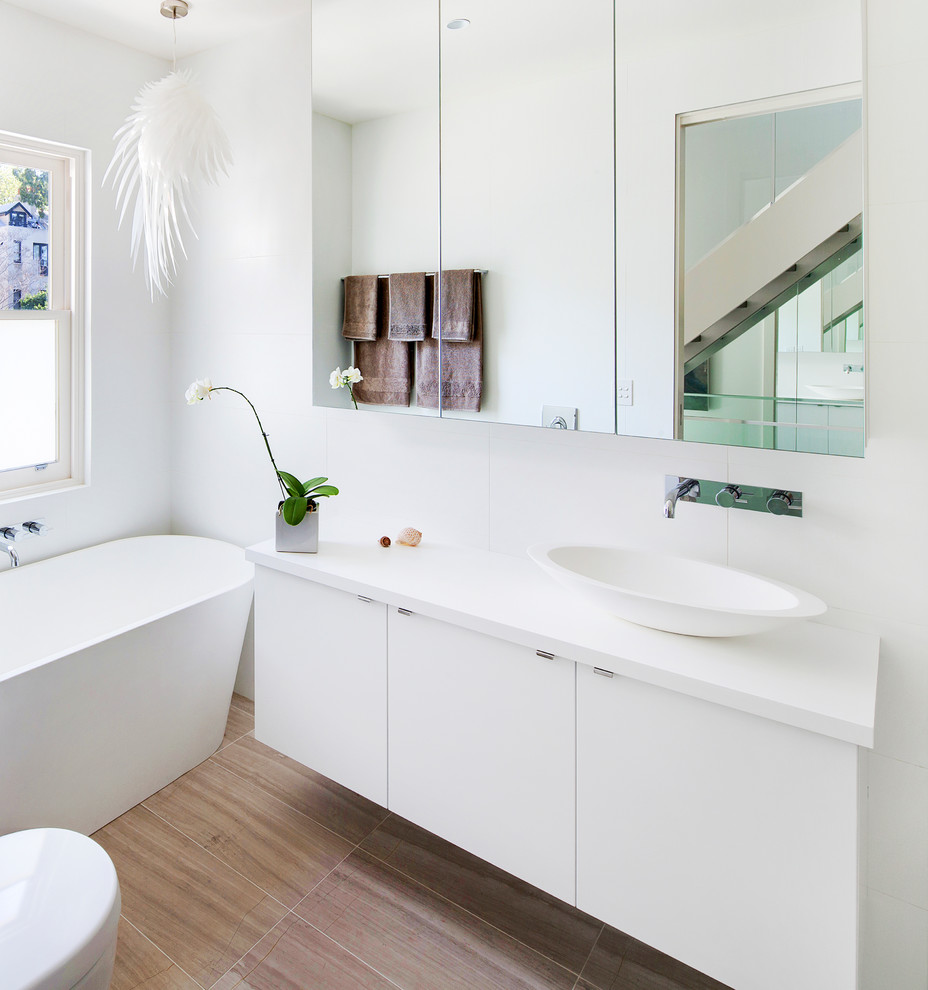 Foto di una stanza da bagno contemporanea con lavabo a bacinella, ante lisce, ante bianche, vasca freestanding e pareti bianche