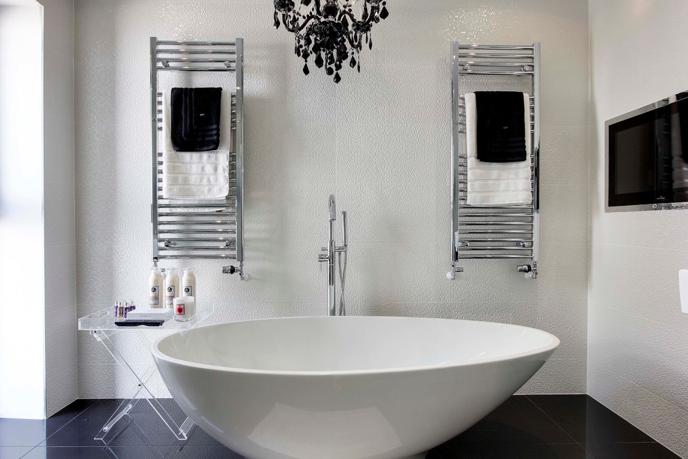 This is an example of a contemporary bathroom in Hertfordshire with a freestanding bath and white tiles.