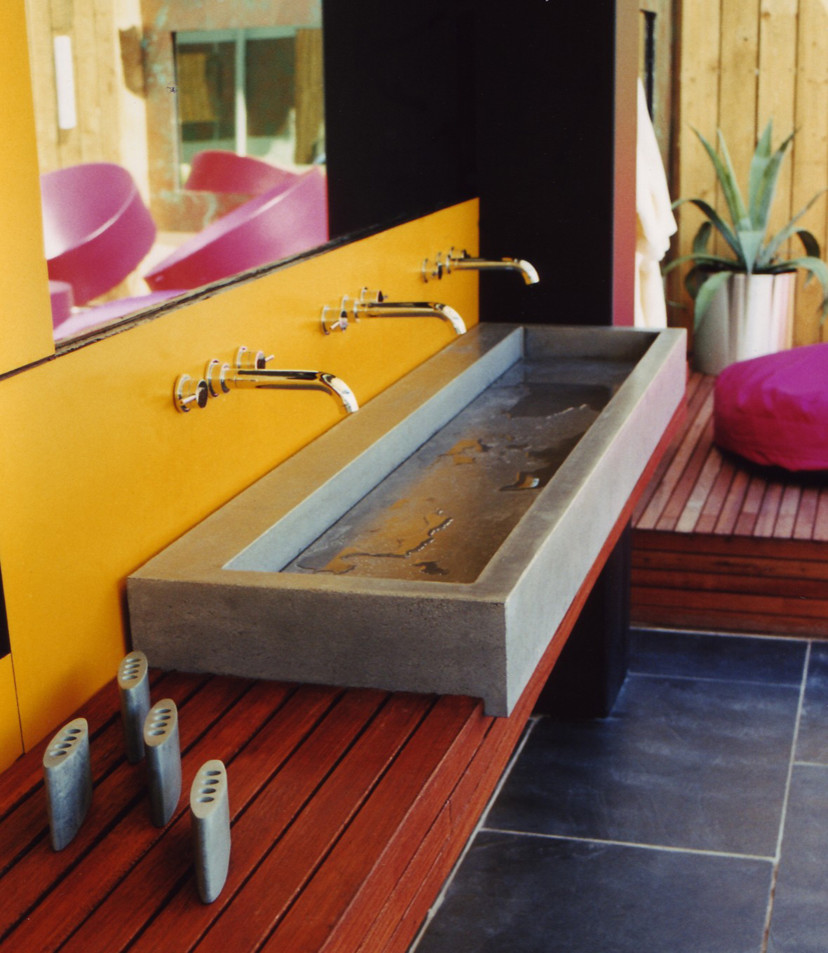 Großes Modernes Badezimmer mit gelben Fliesen, gelber Wandfarbe, Betonboden, Unterbauwaschbecken und Waschtisch aus Holz in London