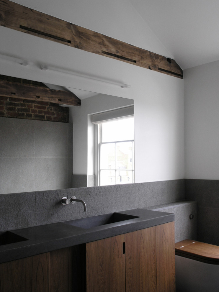 Ejemplo de cuarto de baño ecléctico con baldosas y/o azulejos grises y lavabo integrado