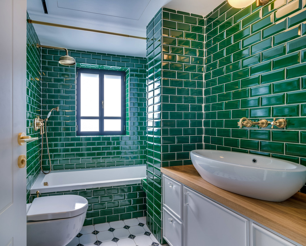 Inspiration for a classic shower room bathroom in Other with recessed-panel cabinets, white cabinets, a built-in bath, a shower/bath combination, a wall mounted toilet, green tiles, metro tiles, green walls, a vessel sink, wooden worktops, white floors and a shower curtain.