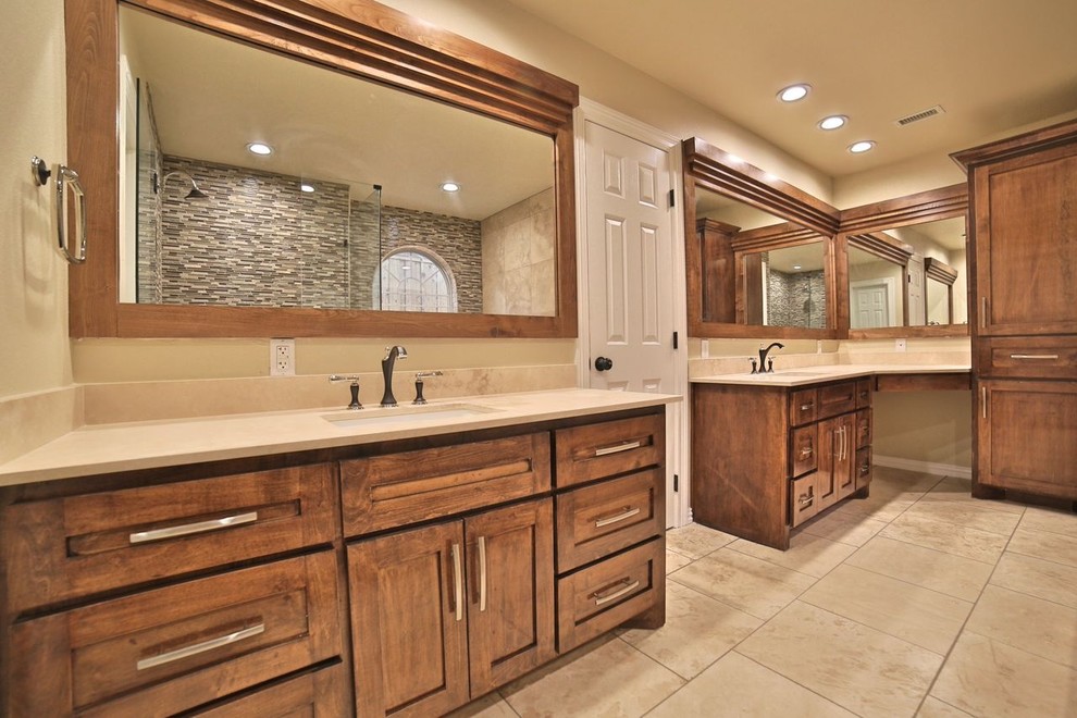Inspiration for a large timeless master beige tile and glass tile travertine floor bathroom remodel in Dallas with an undermount sink, shaker cabinets, light wood cabinets, solid surface countertops, a two-piece toilet and beige walls