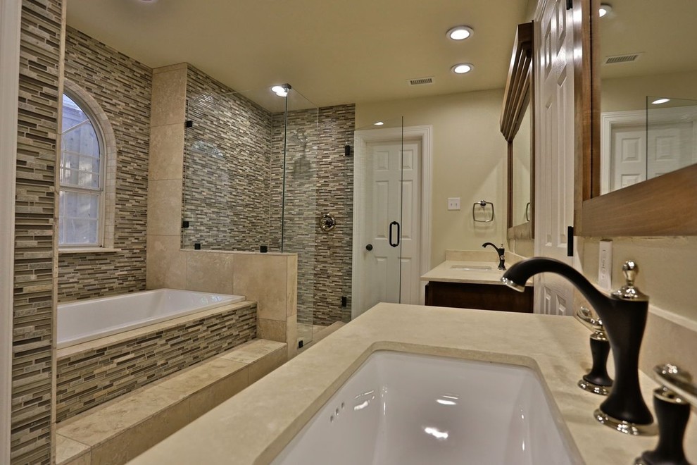 Inredning av ett klassiskt stort en-suite badrum, med ett undermonterad handfat, skåp i shakerstil, skåp i ljust trä, bänkskiva i akrylsten, ett platsbyggt badkar, en öppen dusch, en toalettstol med separat cisternkåpa, beige kakel, glaskakel, beige väggar och travertin golv