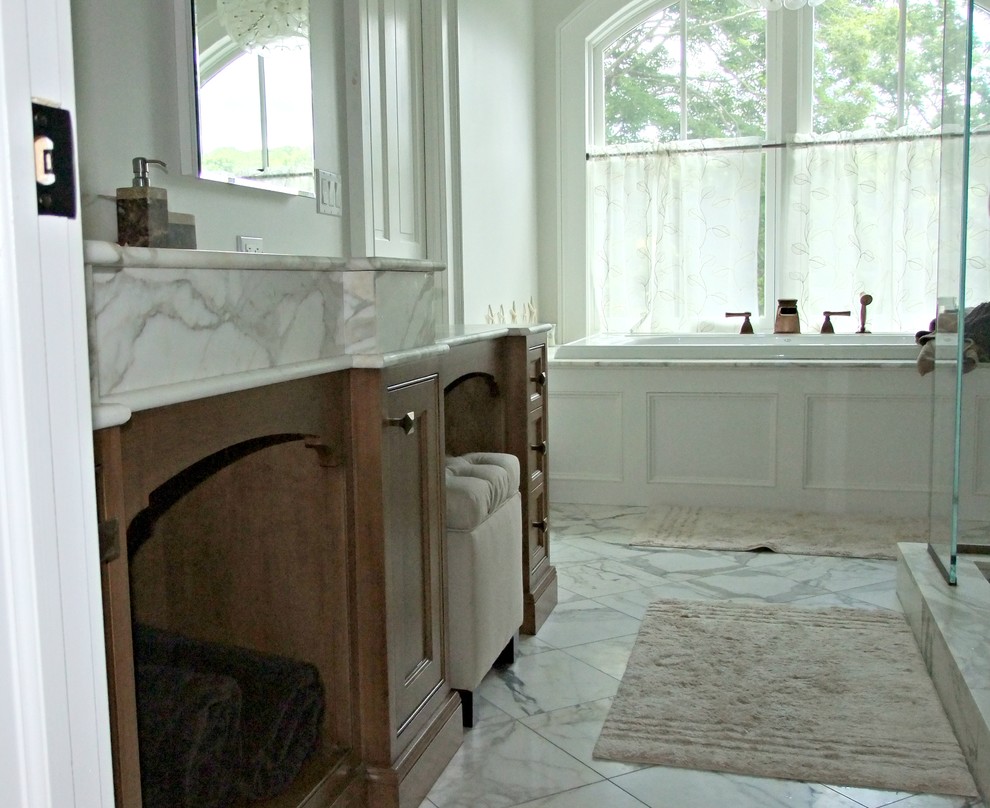 На фото: большая ванная комната в стиле неоклассика (современная классика) с фасадами с декоративным кантом, фасадами цвета дерева среднего тона, белой плиткой, серыми стенами, врезной раковиной и мраморной столешницей с