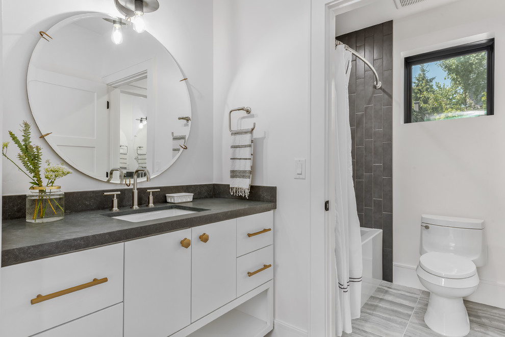 Bathroom - large contemporary kids' gray tile porcelain tile and gray floor bathroom idea in Salt Lake City with flat-panel cabinets, white cabinets, a one-piece toilet, white walls, an undermount sink, quartzite countertops and gray countertops