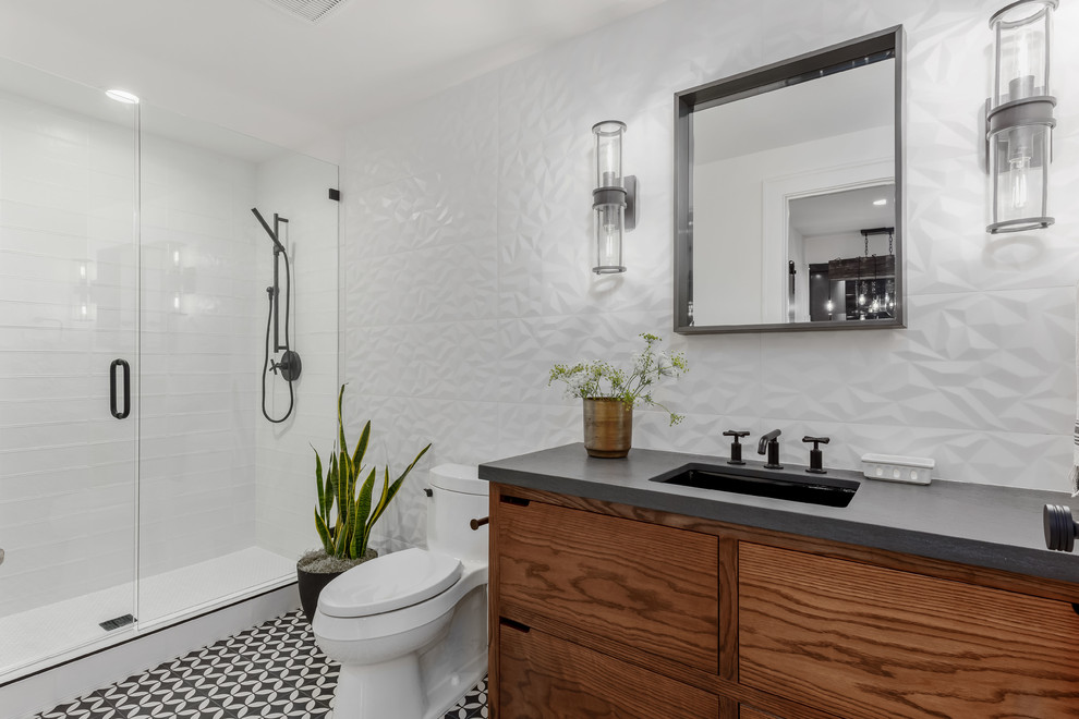 Photo of a large contemporary shower room bathroom in Salt Lake City with flat-panel cabinets, medium wood cabinets, an alcove shower, a one-piece toilet, white tiles, porcelain tiles, white walls, porcelain flooring, a submerged sink, quartz worktops, black floors, a hinged door and grey worktops.