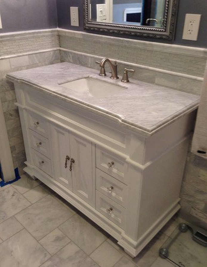 Immagine di una stanza da bagno chic con lavabo sottopiano, consolle stile comò, ante bianche e top in marmo