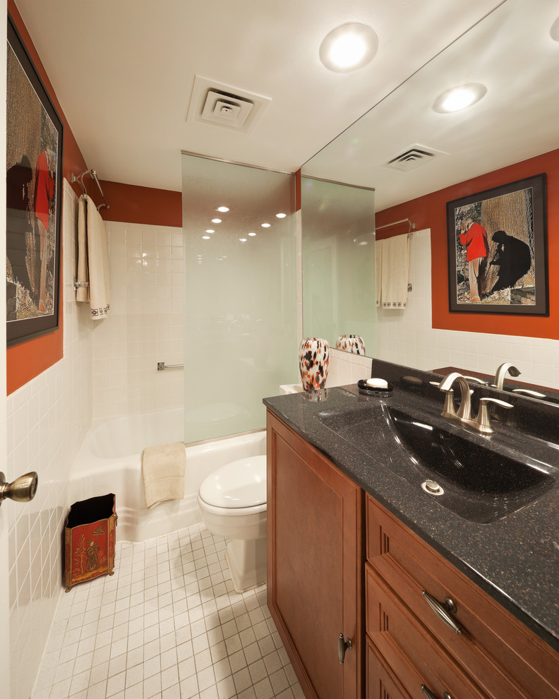 カンザスシティにあるお手頃価格の小さなトラディショナルスタイルのおしゃれな浴室 (落し込みパネル扉のキャビネット、中間色木目調キャビネット、アルコーブ型浴槽、シャワー付き浴槽	、分離型トイレ、白いタイル、磁器タイル、赤い壁、一体型シンク、人工大理石カウンター、セラミックタイルの床、白い床、オープンシャワー) の写真