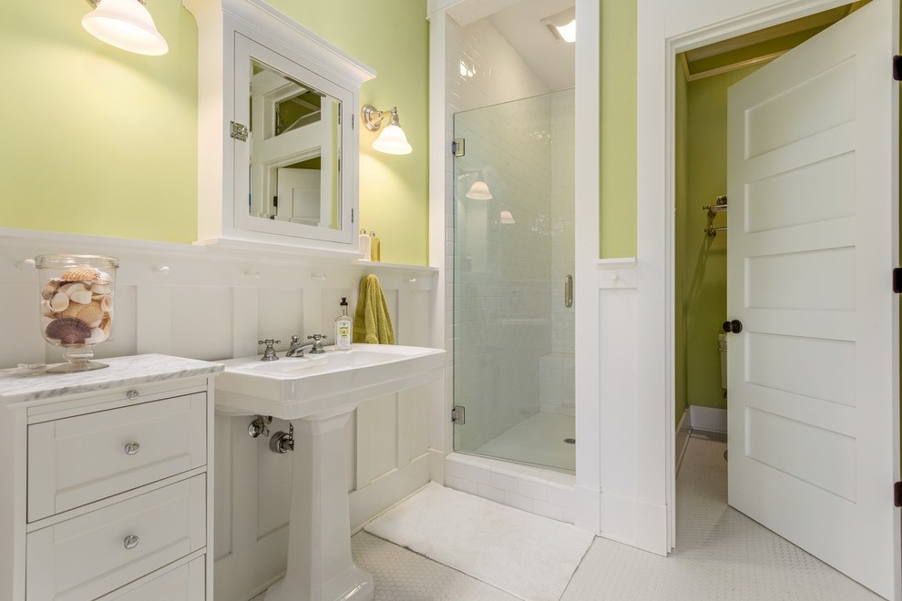Beach style white tile white floor bathroom photo in Hawaii with recessed-panel cabinets, white cabinets, an undermount sink, marble countertops, a hinged shower door and white countertops