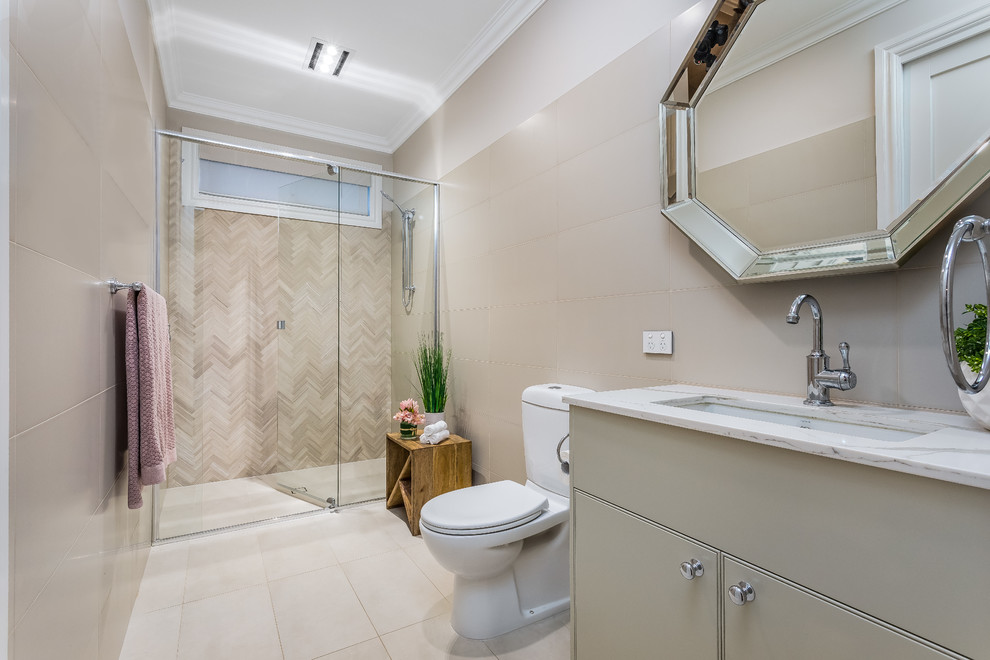 Alcove shower - mid-sized contemporary kids' beige tile and porcelain tile porcelain tile and beige floor alcove shower idea in Brisbane with shaker cabinets, blue cabinets, a one-piece toilet, beige walls, an undermount sink, quartz countertops, a hinged shower door and white countertops