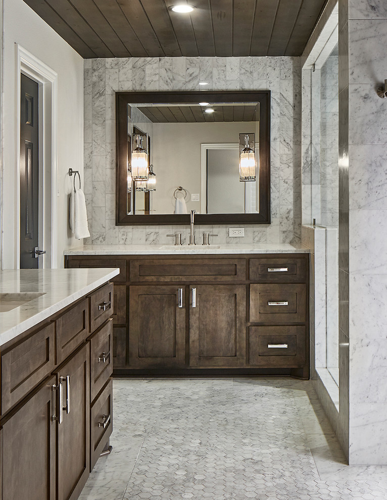 Corner shower - transitional gray tile gray floor corner shower idea in Dallas with recessed-panel cabinets, dark wood cabinets, beige walls, an undermount sink, a hinged shower door and gray countertops