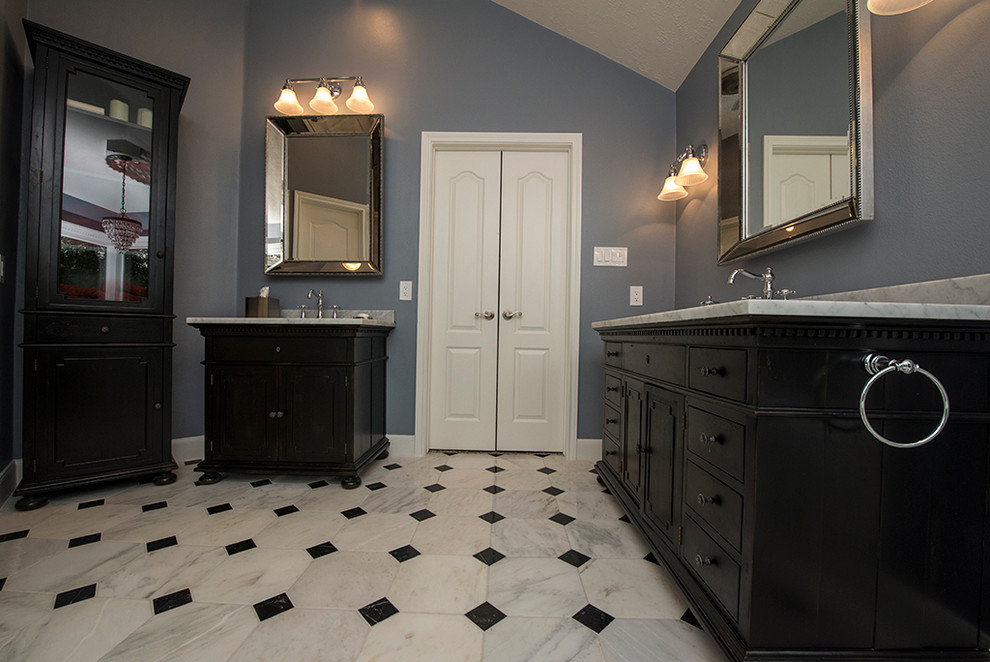 Inspiration for a mid-sized transitional master black and white tile, white tile and stone slab marble floor bathroom remodel in Houston with raised-panel cabinets, dark wood cabinets, blue walls, an undermount sink and marble countertops