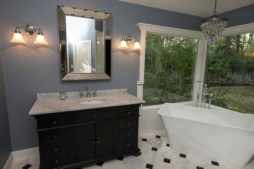 Inredning av ett klassiskt mellanstort en-suite badrum, med luckor med upphöjd panel, skåp i mörkt trä, ett fristående badkar, en hörndusch, svart och vit kakel, vit kakel, stenhäll, blå väggar, marmorgolv, ett undermonterad handfat och marmorbänkskiva
