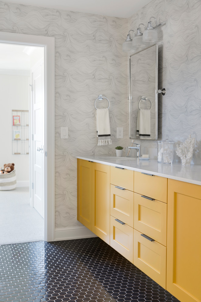 Klassisches Badezimmer mit Schrankfronten im Shaker-Stil, gelben Schränken, grauer Wandfarbe, Unterbauwaschbecken, schwarzem Boden, weißer Waschtischplatte und Tapetenwänden in Minneapolis