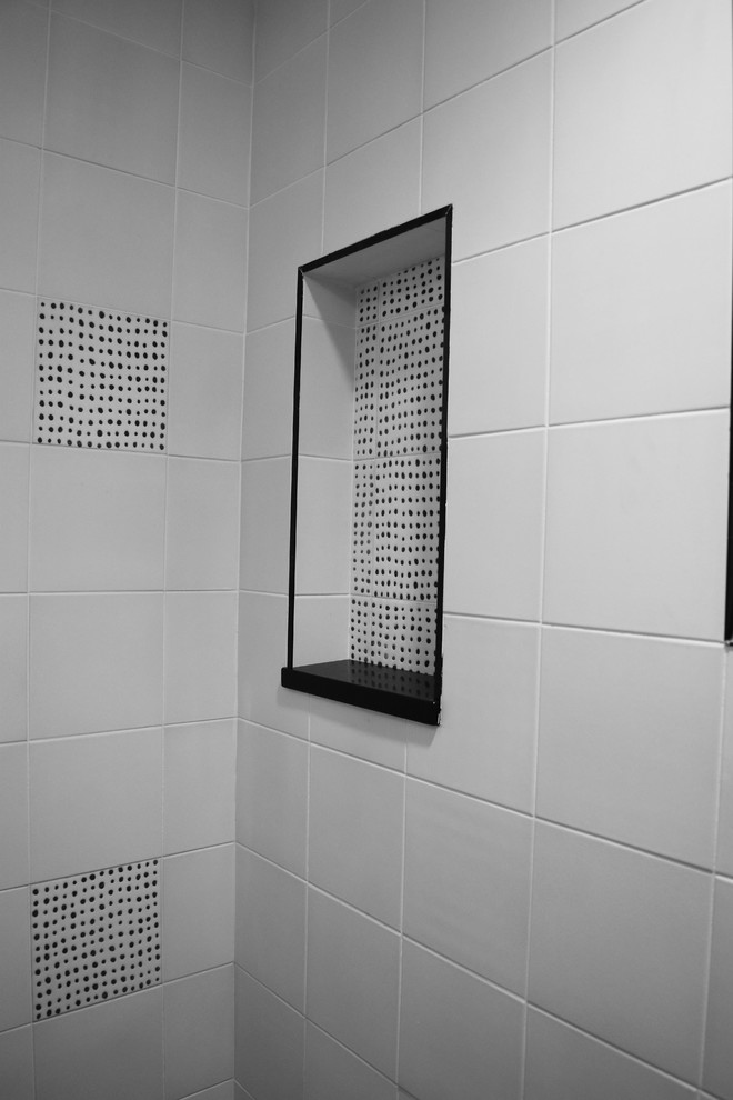 Imagen de cuarto de baño minimalista con baldosas y/o azulejos blancas y negros, aseo y ducha, encimera de azulejos y encimeras negras