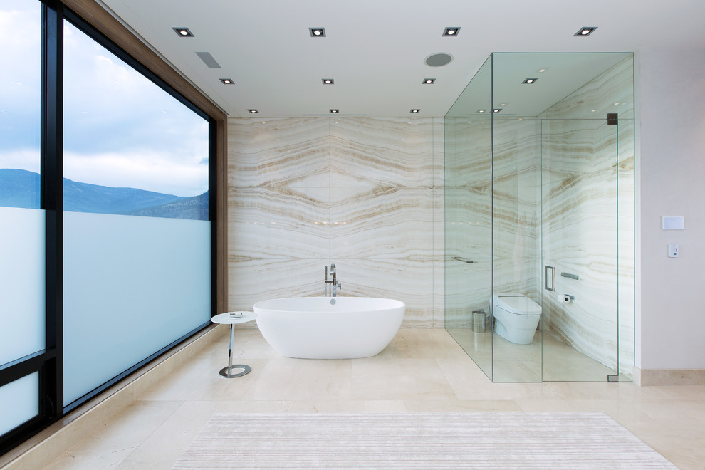 Foto di un'ampia stanza da bagno padronale moderna con vasca freestanding, WC monopezzo, piastrelle beige, lastra di pietra, pareti bianche, pavimento in pietra calcarea e pavimento beige