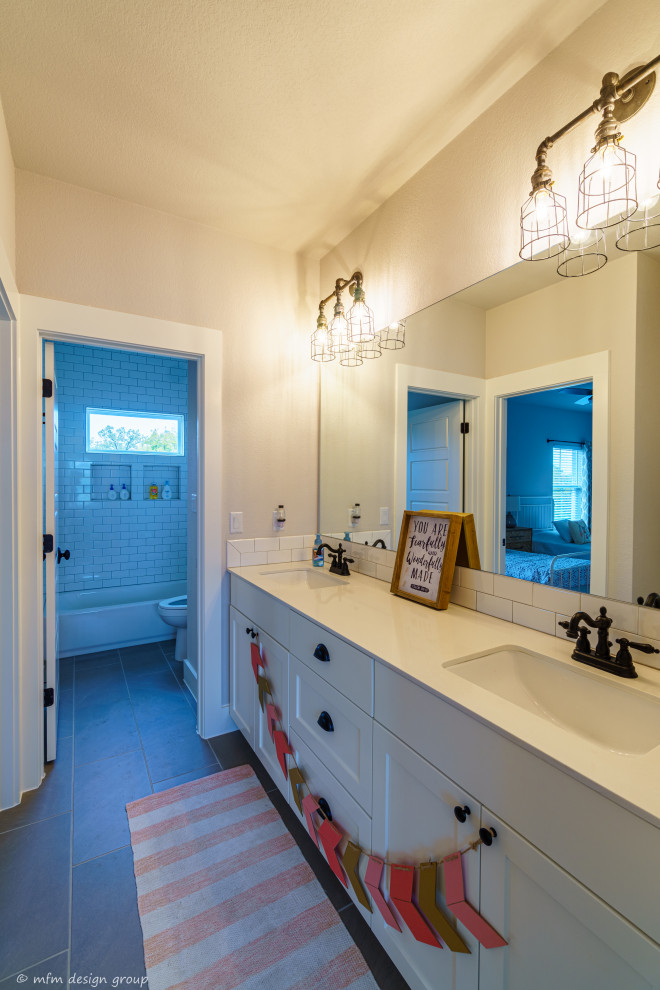 Example of a mid-sized farmhouse kids' white tile and subway tile ceramic tile and gray floor bathroom design in Austin with recessed-panel cabinets, white cabinets, a two-piece toilet, gray walls, an undermount sink, quartzite countertops and white countertops