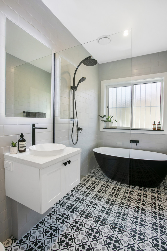 Inspiration för mellanstora moderna vitt badrum, med vita skåp, en öppen dusch, grå kakel, porslinskakel, vita väggar, klinkergolv i porslin, ett fristående handfat, bänkskiva i kvarts och med dusch som är öppen
