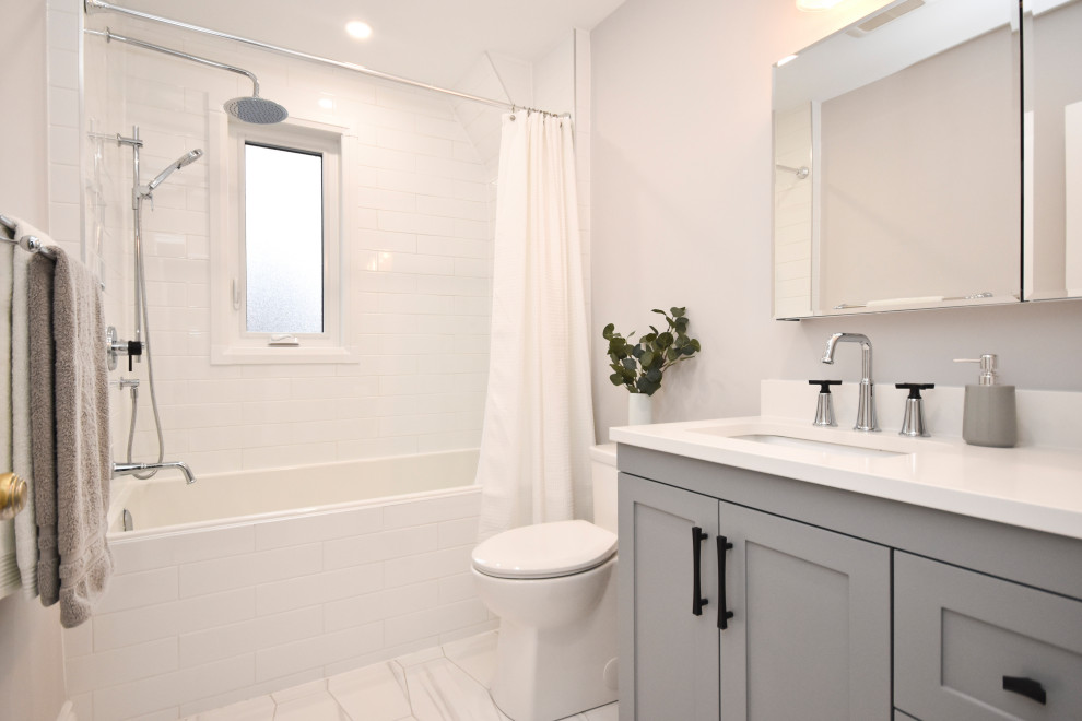 Bild på ett litet funkis vit vitt badrum, med grå skåp, en dusch i en alkov, en toalettstol med hel cisternkåpa, vit kakel, porslinskakel, grå väggar, klinkergolv i porslin, ett undermonterad handfat, bänkskiva i kvarts, vitt golv och dusch med duschdraperi