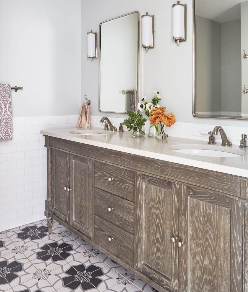 Exemple d'une salle de bain chic en bois brun avec un placard avec porte à panneau encastré, un carrelage blanc, un mur gris, un lavabo encastré, un sol multicolore, un plan de toilette gris, meuble double vasque et meuble-lavabo encastré.