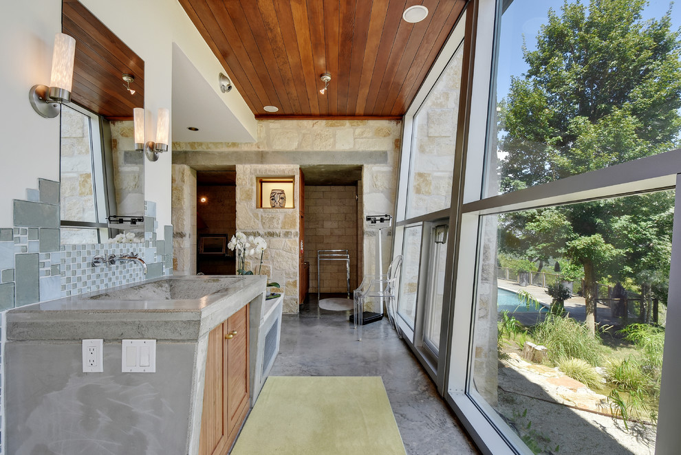 Стильный дизайн: главная ванная комната в современном стиле с монолитной раковиной, фасадами цвета дерева среднего тона, столешницей из бетона и серой плиткой - последний тренд
