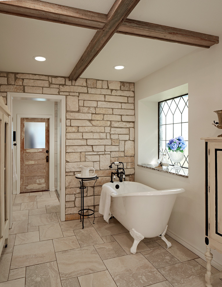 Cette image montre une salle de bain rustique avec une baignoire sur pieds et un mur blanc.
