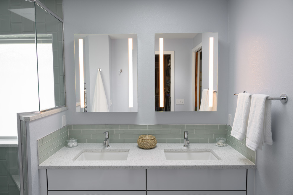 На фото: главная ванная комната среднего размера в современном стиле с плоскими фасадами, белыми фасадами, душем в нише, серой плиткой, стеклянной плиткой, белыми стенами, врезной раковиной, столешницей из гранита и серой столешницей с