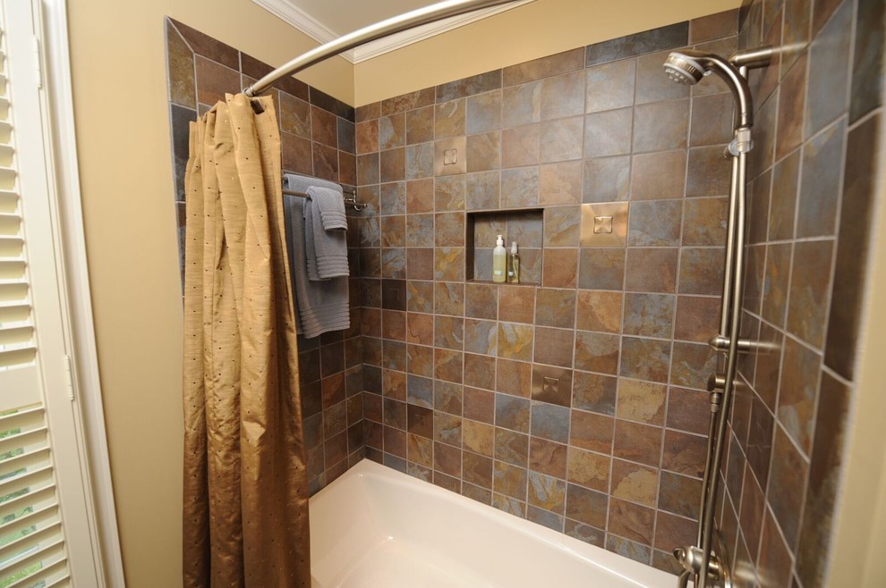 Bild på ett funkis badrum, med släta luckor, skåp i mellenmörkt trä, ett badkar i en alkov, en dusch i en alkov, en toalettstol med separat cisternkåpa, skifferkakel, beige väggar, skiffergolv, ett undermonterad handfat och dusch med duschdraperi