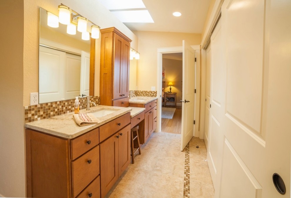 Large contemporary ensuite bathroom in Seattle with a submerged sink, recessed-panel cabinets, light wood cabinets, granite worktops, beige walls, ceramic flooring, a freestanding bath, a walk-in shower, a two-piece toilet, brown tiles and glass tiles.