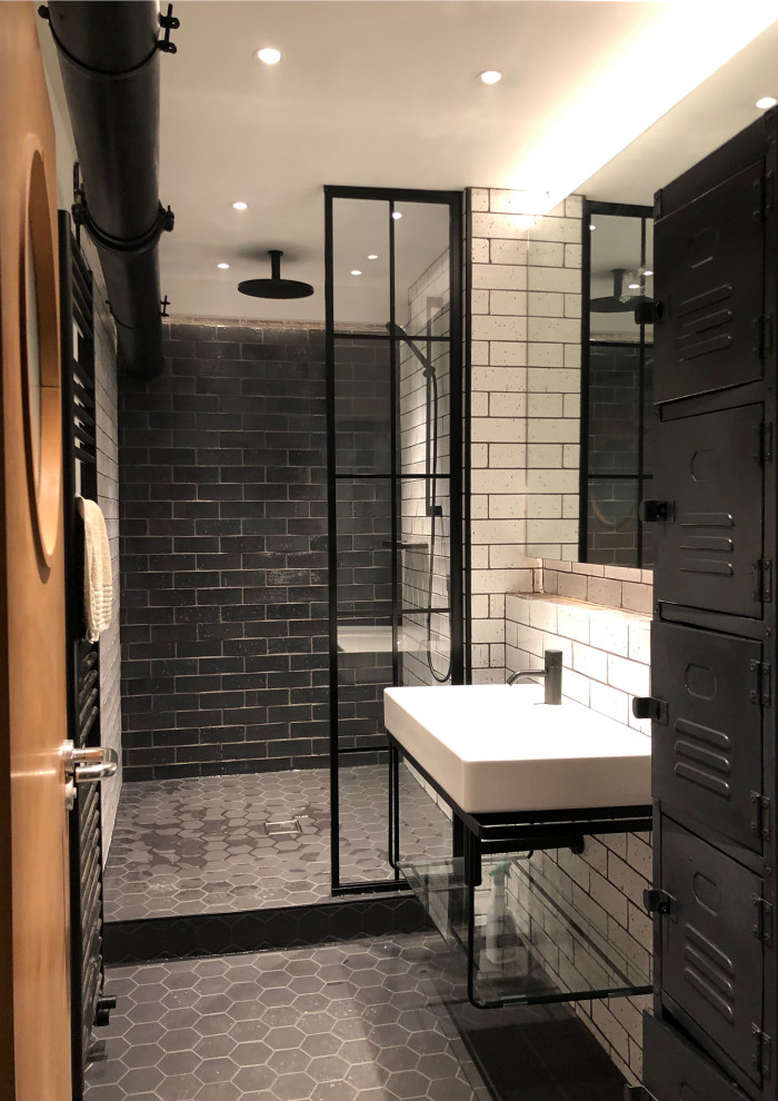 ロンドンにあるお手頃価格の中くらいなインダストリアルスタイルのおしゃれなバスルーム (浴槽なし) (アルコーブ型シャワー、サブウェイタイル、黒い床、オープンシェルフ、黒いキャビネット、モノトーンのタイル、壁付け型シンク、オープンシャワー、セメントタイルの床) の写真