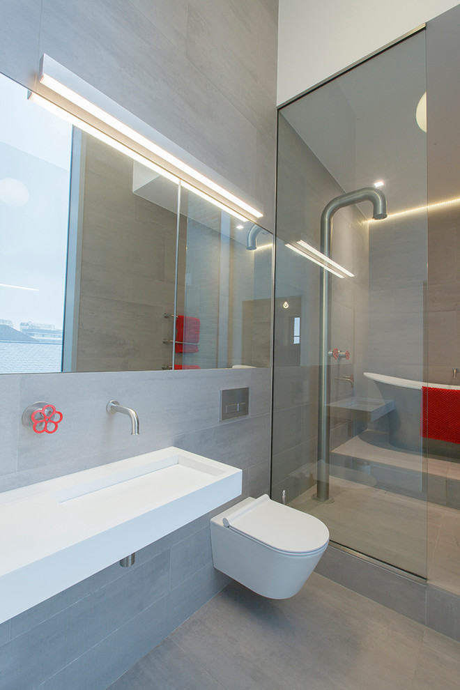ロンドンにあるコンテンポラリースタイルのおしゃれな浴室 (置き型浴槽、壁付け型シンク、壁掛け式トイレ) の写真