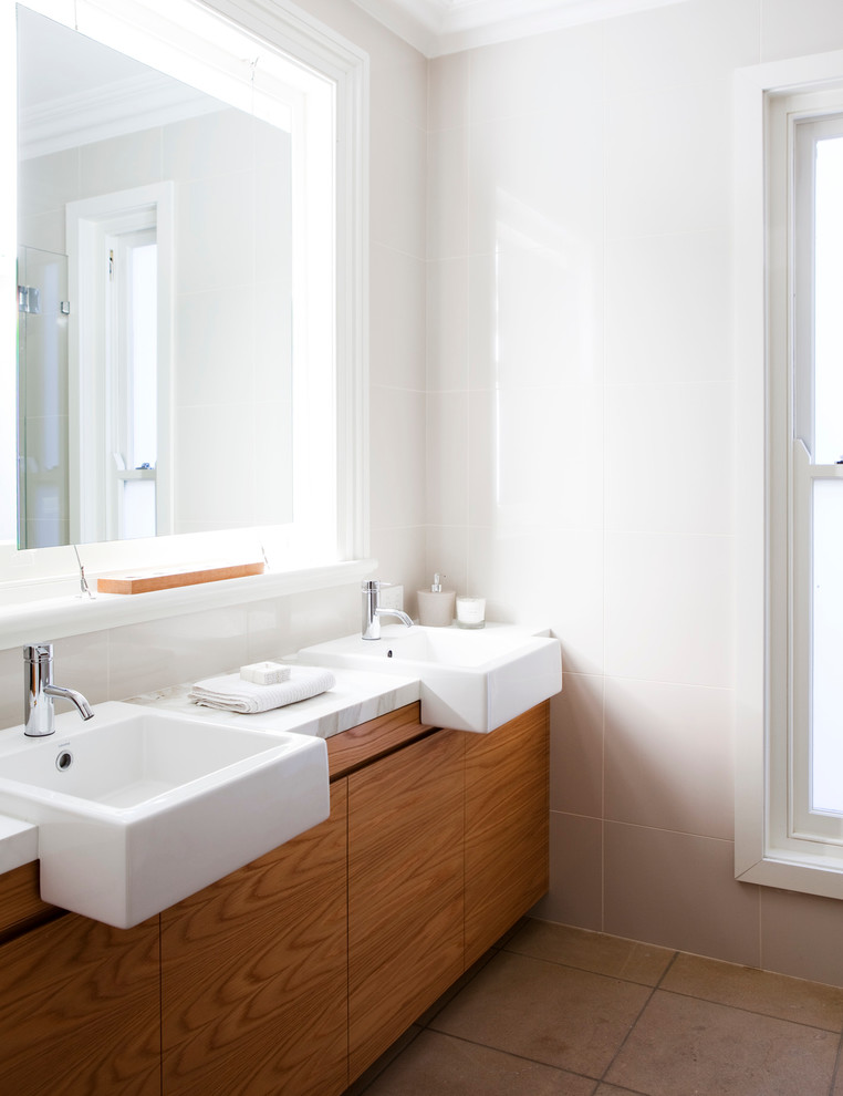 Imagen de cuarto de baño rectangular contemporáneo con lavabo sobreencimera, armarios con paneles lisos, puertas de armario de madera oscura y baldosas y/o azulejos blancos