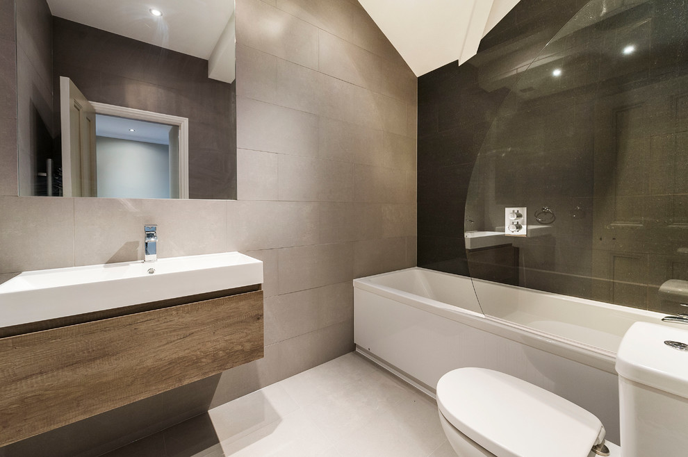 Idéer för att renovera ett mellanstort funkis en-suite badrum, med en dusch i en alkov, en vägghängd toalettstol, flerfärgad kakel, flerfärgade väggar, ett integrerad handfat, kaklad bänkskiva och ett badkar i en alkov