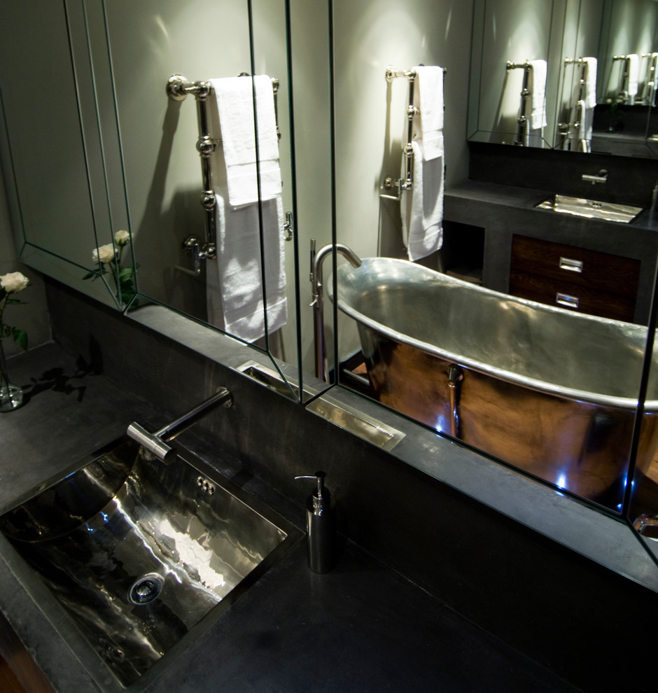 Modelo de cuarto de baño principal actual pequeño con puertas de armario de madera en tonos medios y paredes grises