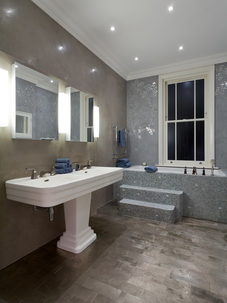 Photo of a large contemporary ensuite bathroom in London with a built-in bath, grey walls, ceramic flooring, a pedestal sink, flat-panel cabinets, an alcove shower and grey tiles.