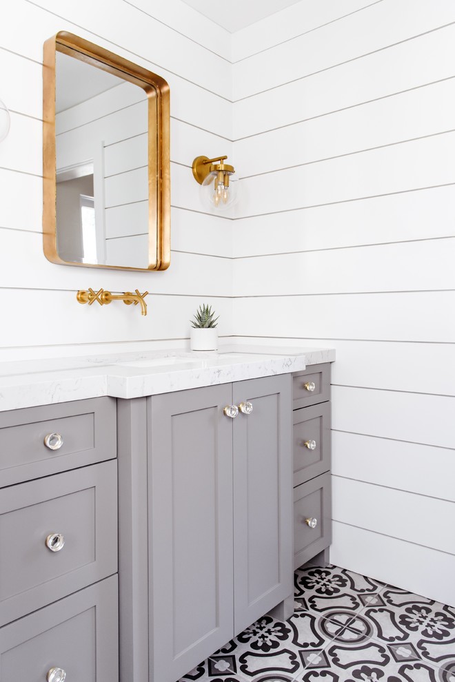 Immagine di una stanza da bagno con doccia country di medie dimensioni con ante in stile shaker, ante grigie, pareti bianche, pavimento in cementine, lavabo sottopiano, top in marmo e pavimento bianco