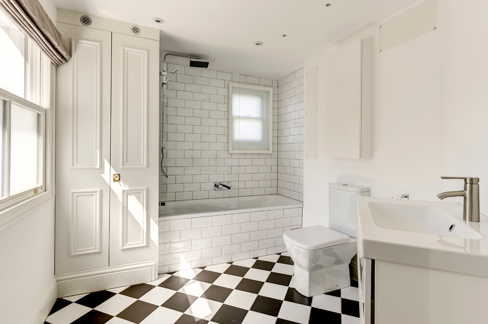 Modernes Badezimmer mit Badewanne in Nische und buntem Boden in London