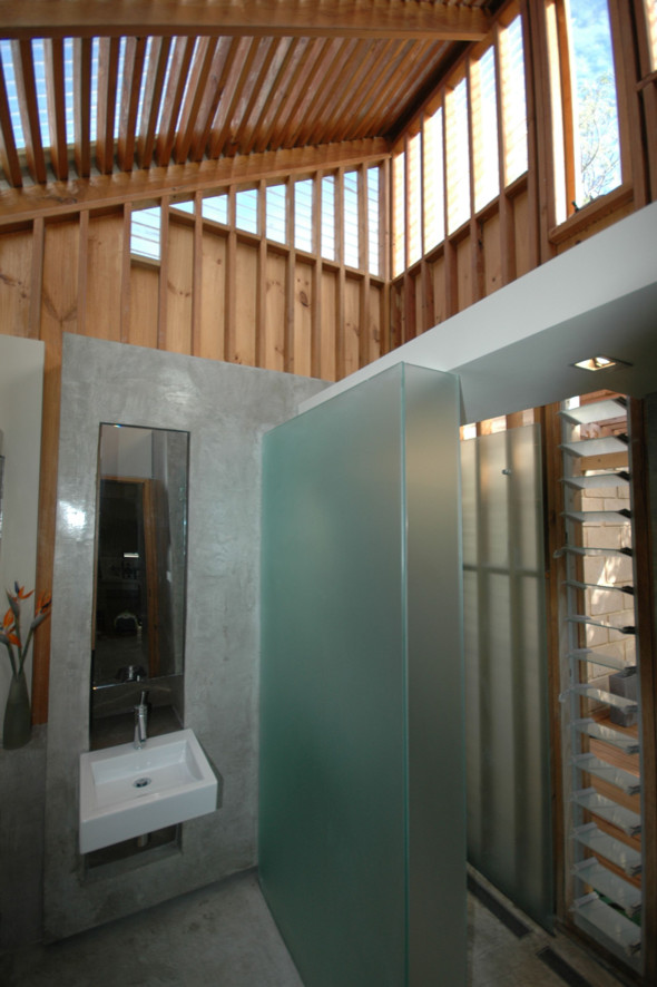 Idéer för att renovera ett litet funkis badrum med dusch, med ett väggmonterat handfat, luckor med glaspanel, skåp i mellenmörkt trä, bänkskiva i betong, en dusch i en alkov, en toalettstol med hel cisternkåpa, grå kakel, cementkakel, grå väggar och betonggolv