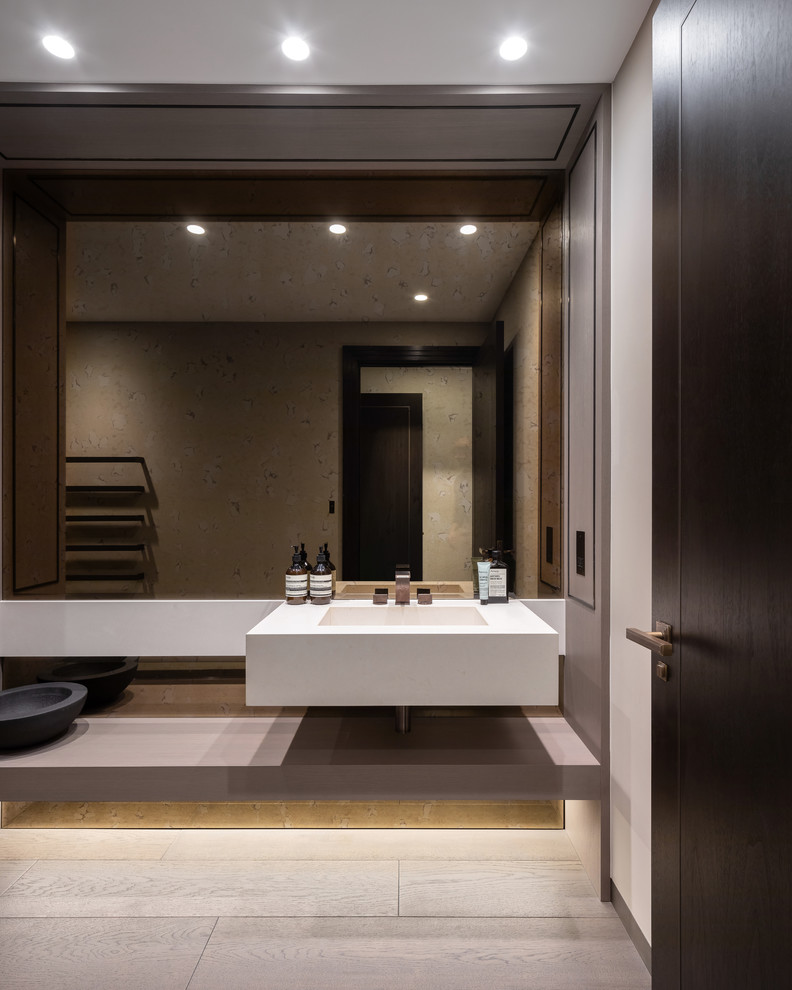 Modelo de cuarto de baño contemporáneo con paredes blancas, lavabo integrado, suelo gris y encimeras blancas